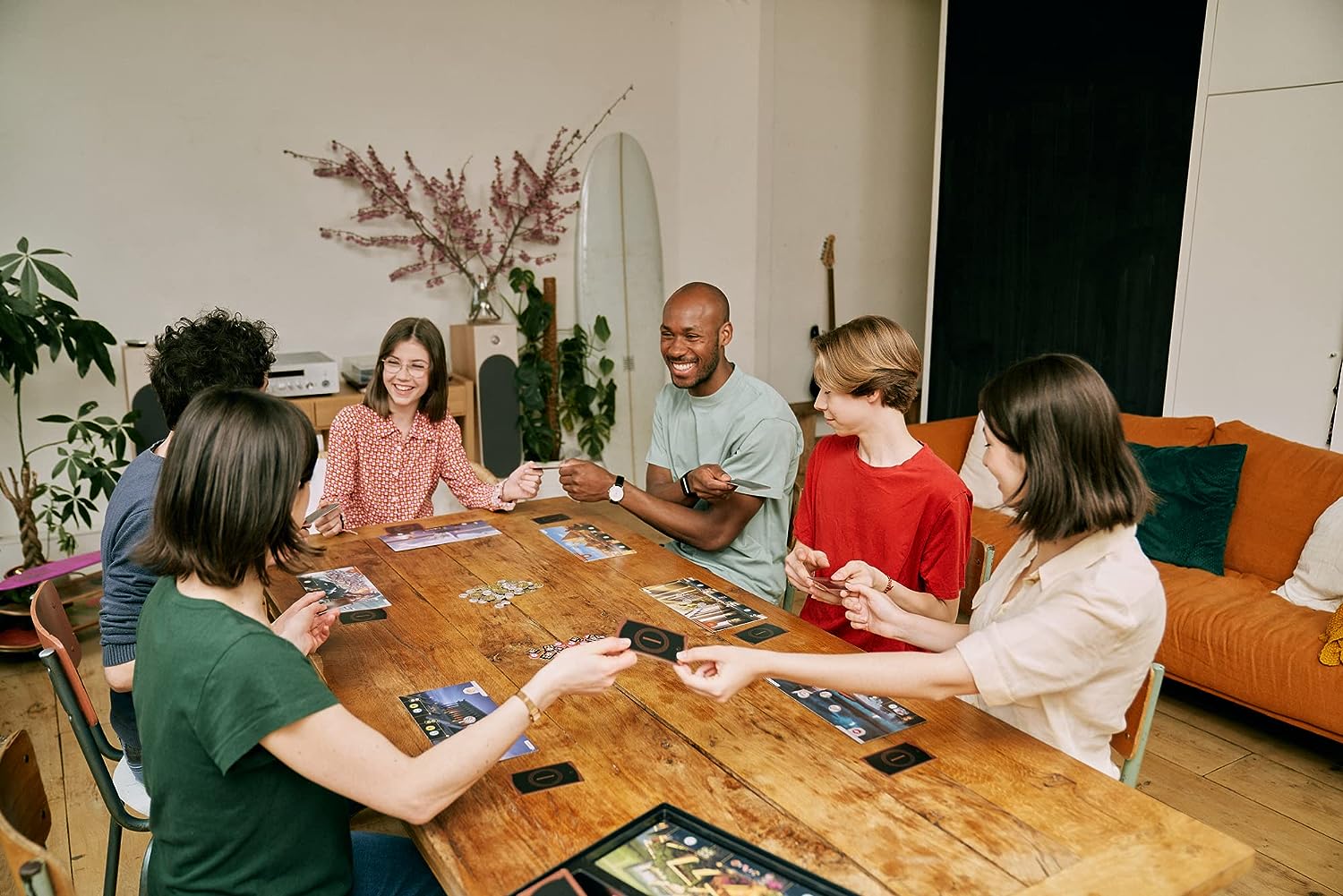 A group of people play the 7 Wonders board game.