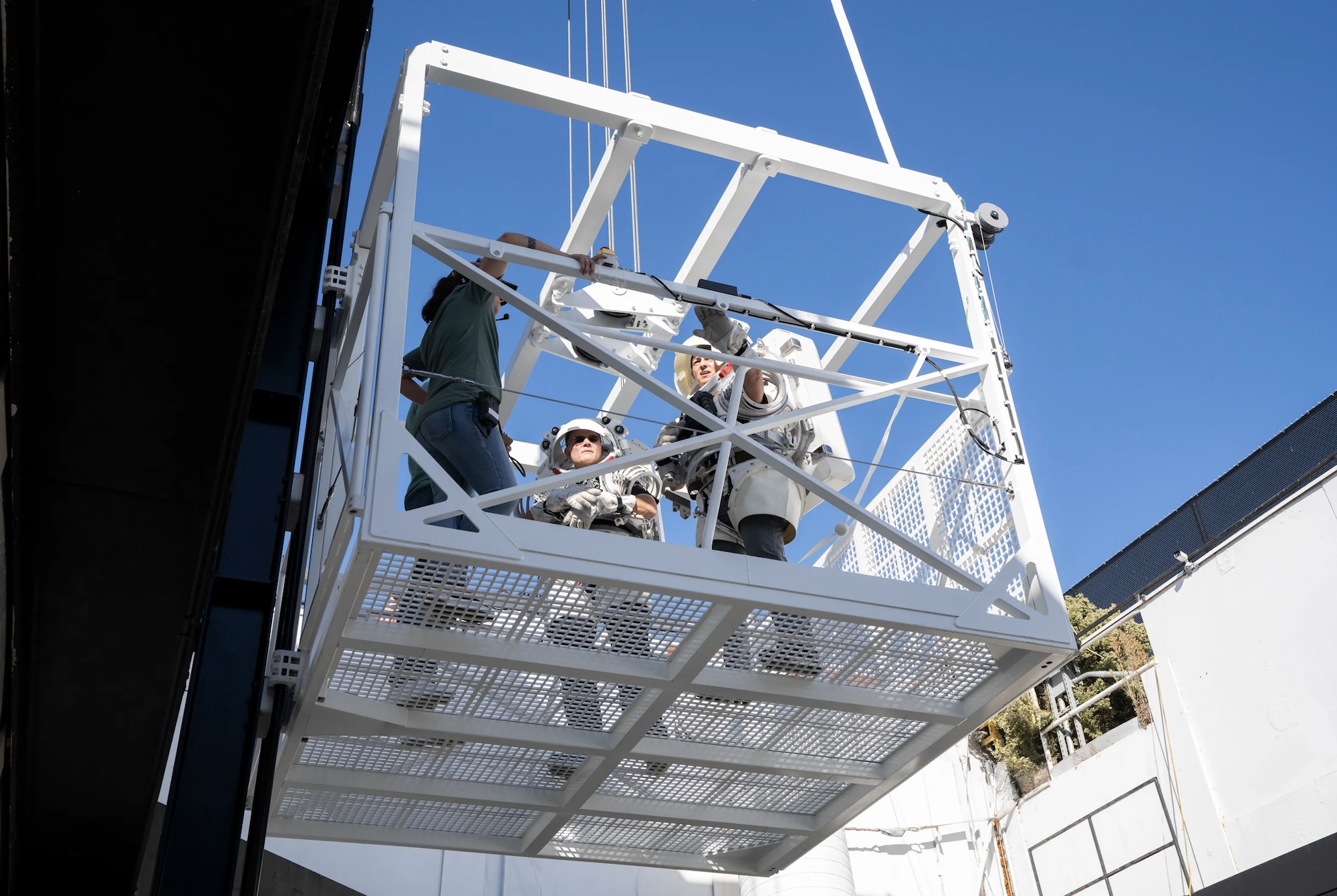 Two NASA astronauts test an elevator for the Artemis III lunar mission.