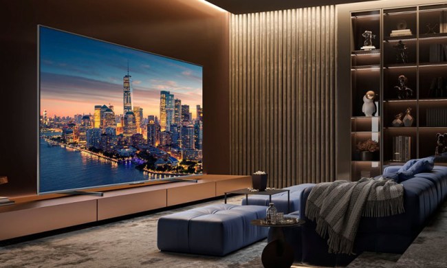 The Hisense 100-inch U76 QLED TV placed in a living room environment next to a sofa and wall-mounted.