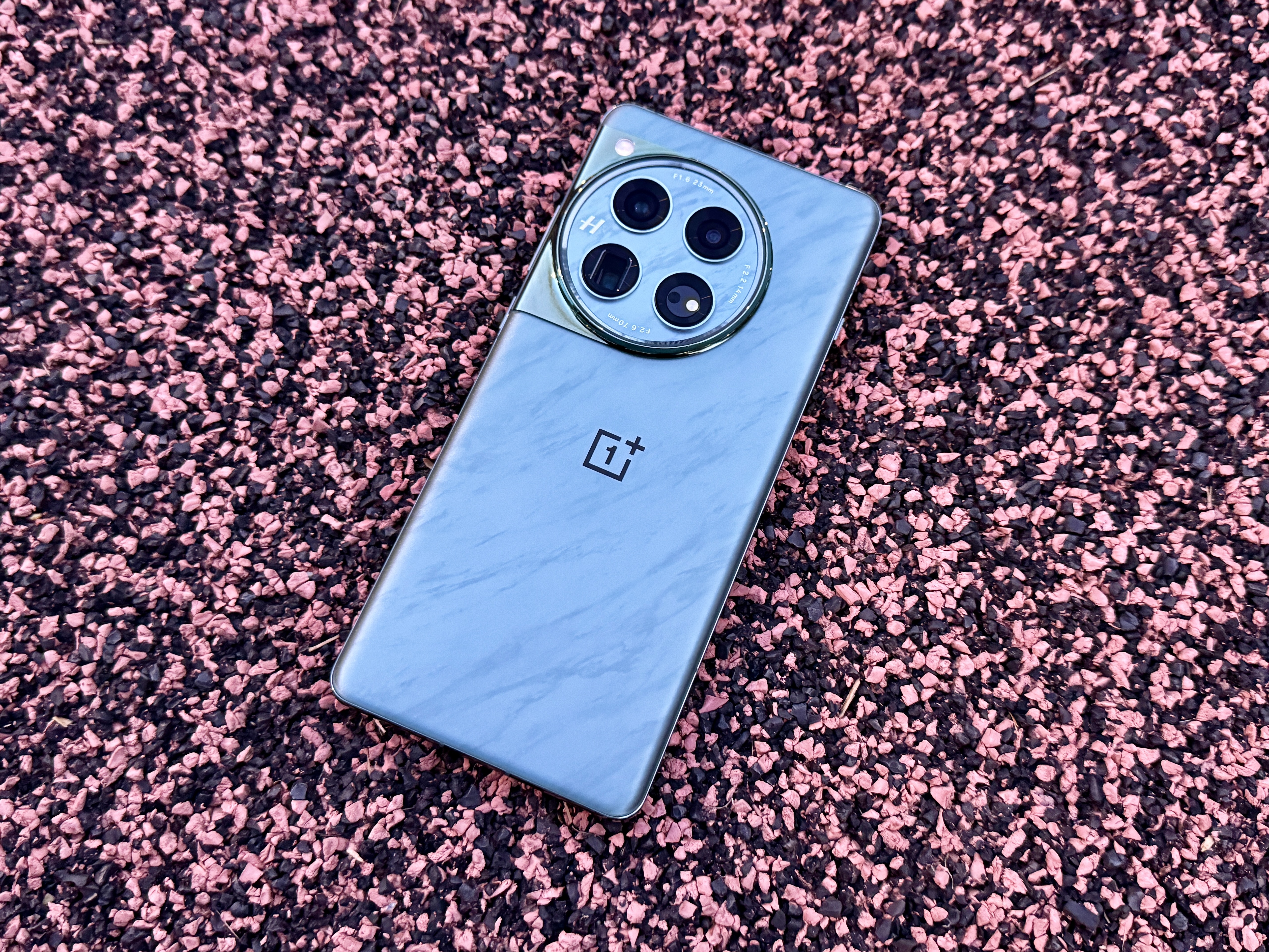 OnePlus 12 Flowy Emerald laying flat on astroturf.