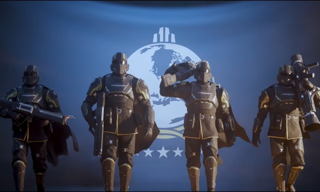 Four soldiers walk in front of a blue Super Earth flag in the Helldivers 2 trailer.