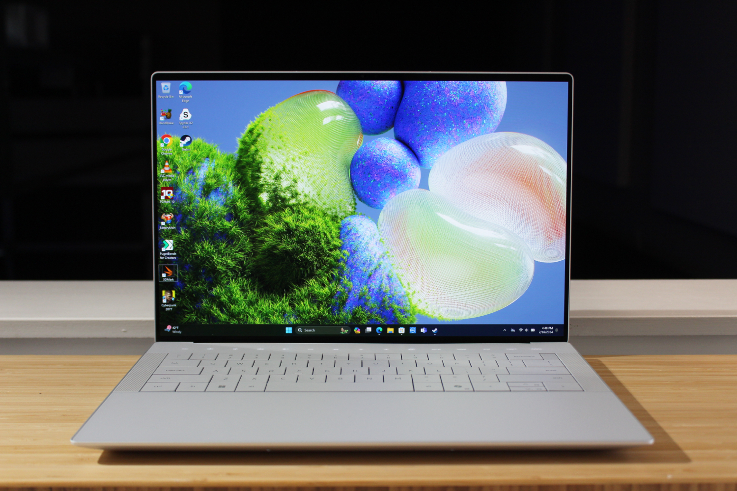 The Dell XPS 14 open on a wooden table.