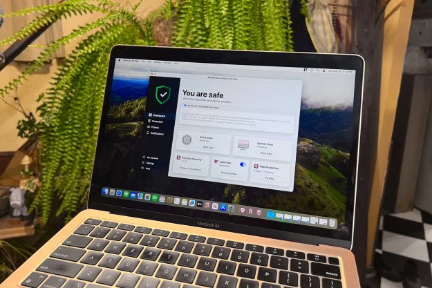 A MacBook Air is shown with the Bitdefender for Mac dashboard open.