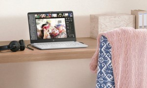 The HP 14-inch laptop on a small desk with some headphones.