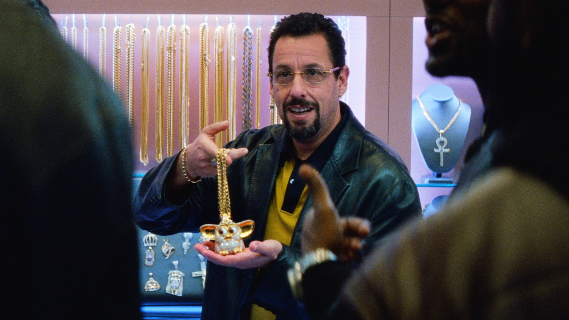 Adam Sandler as Howard Ratner holding a piece of jewelry in Uncut Gems.