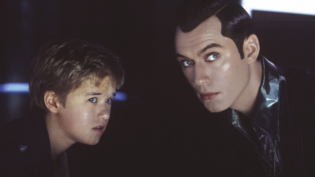 Haley Joel Osment and Jude Law both looking at something while crouched down hiding in a scene from A.I. Artificial Intelligence.