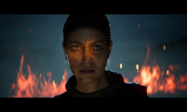 Senua staring off into the distance in front of a big fire in Hellblade 2.