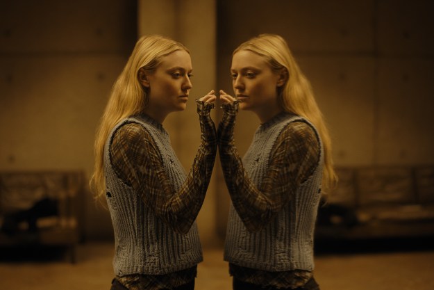 Dakota Fanning stands in front of a mirror in The Watchers.