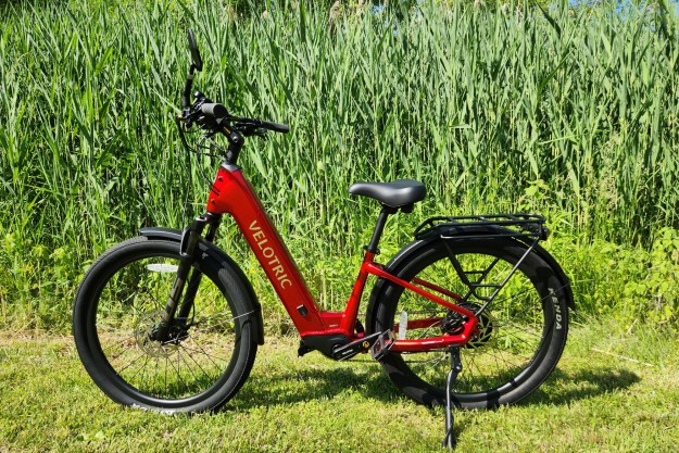 Velotric Discover 2 left profile view with parked by a pond with tall aquatic grasses.