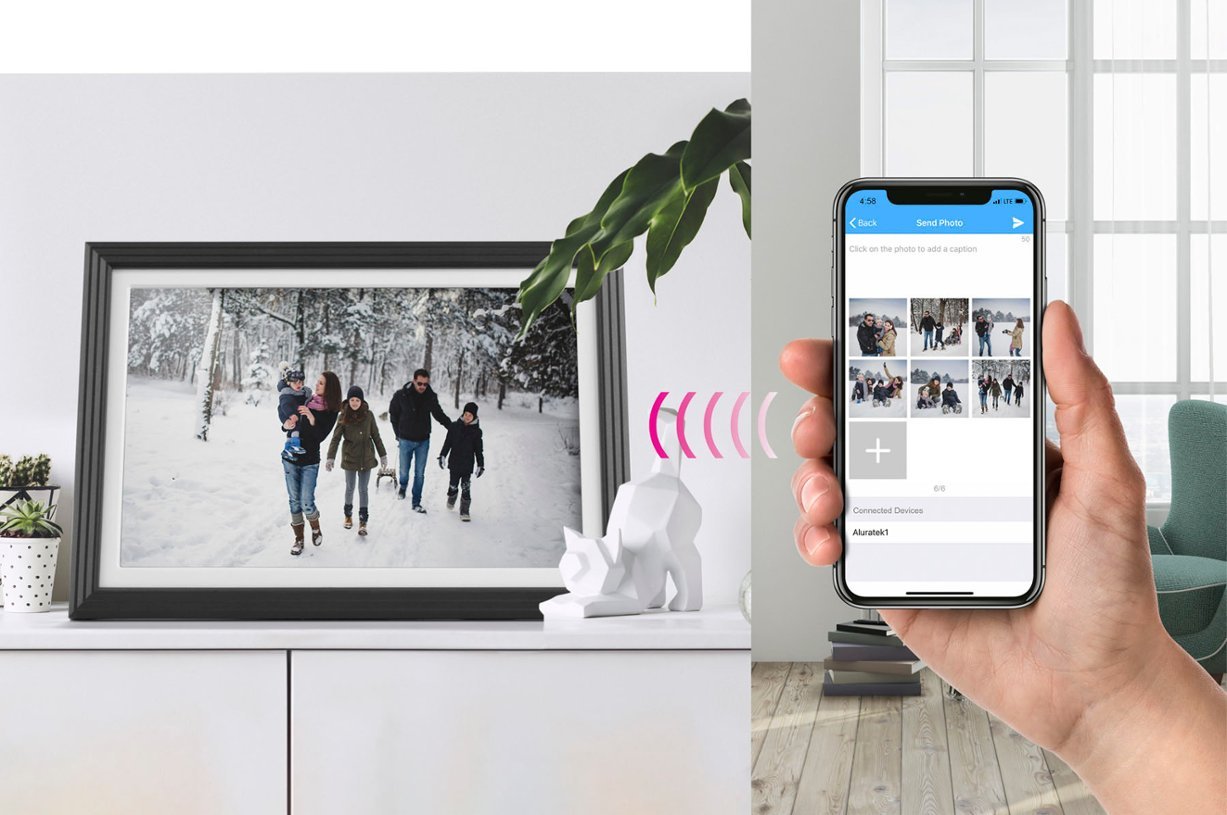 A person holding a smartphone that is syncing to the Aluratek 10-inch Digital Photo Frame.