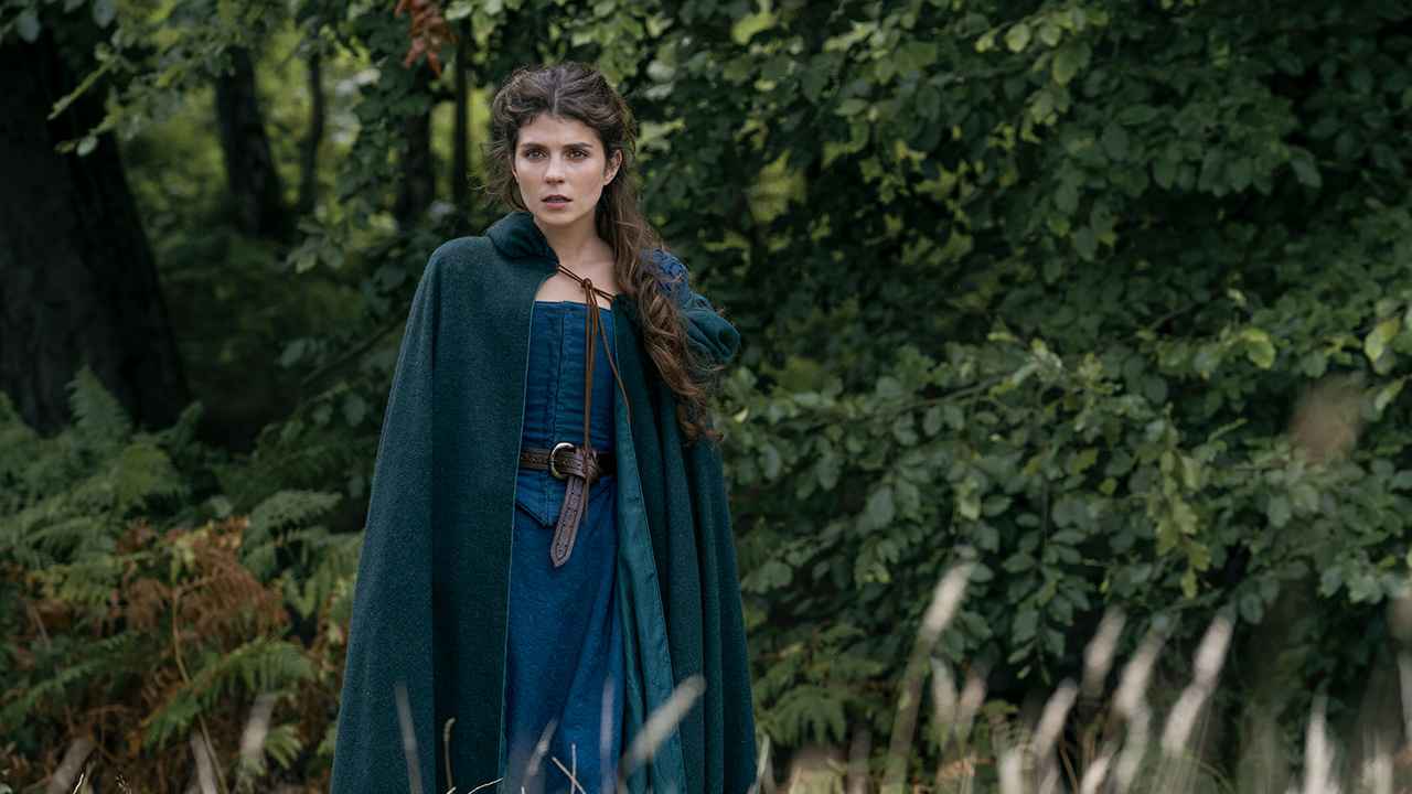 A woman dressed from the 1500s standing in a field in a scene from My Lady Jane on Amazon Prime Video.