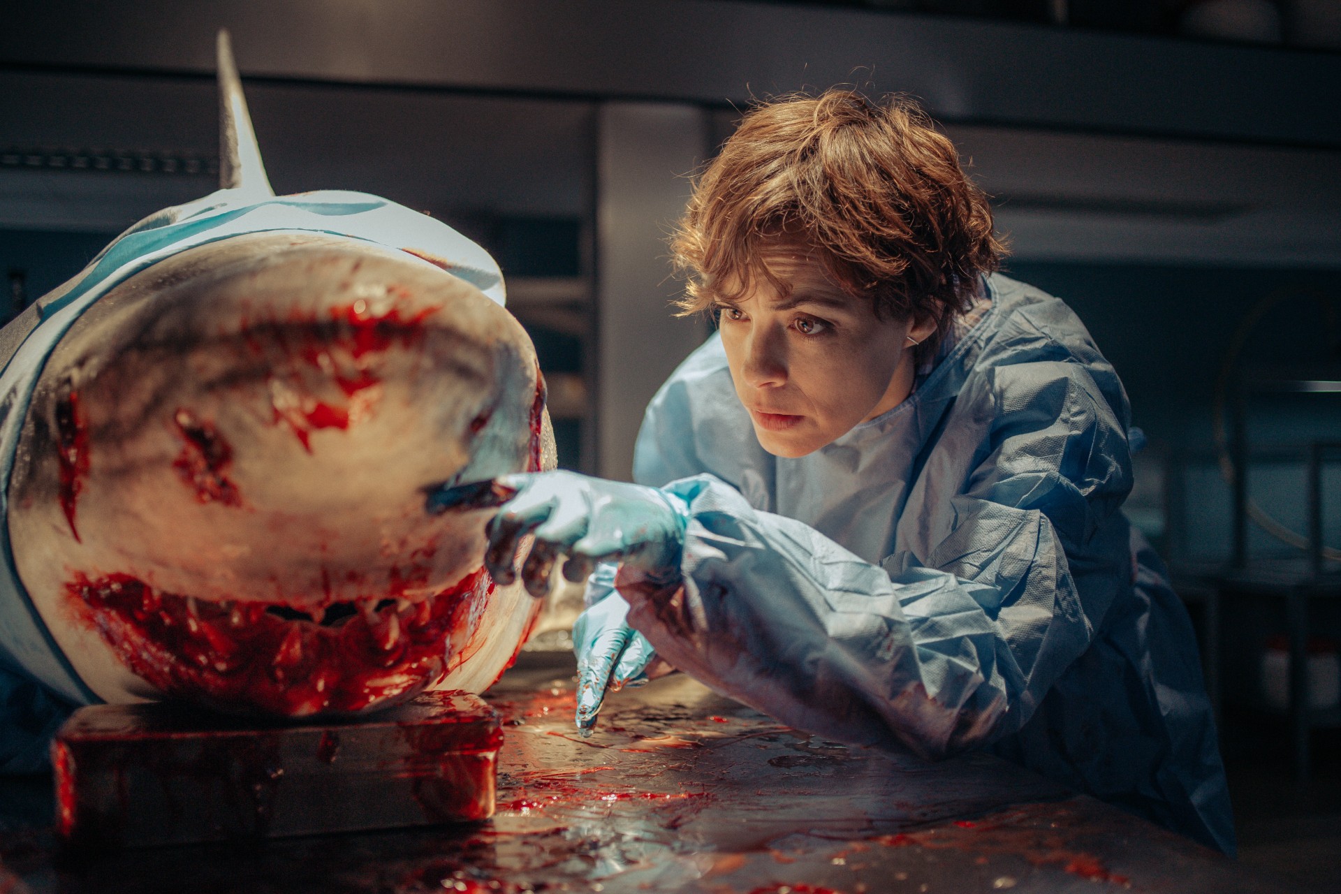 A woman examines a dead shark in Under Paris.