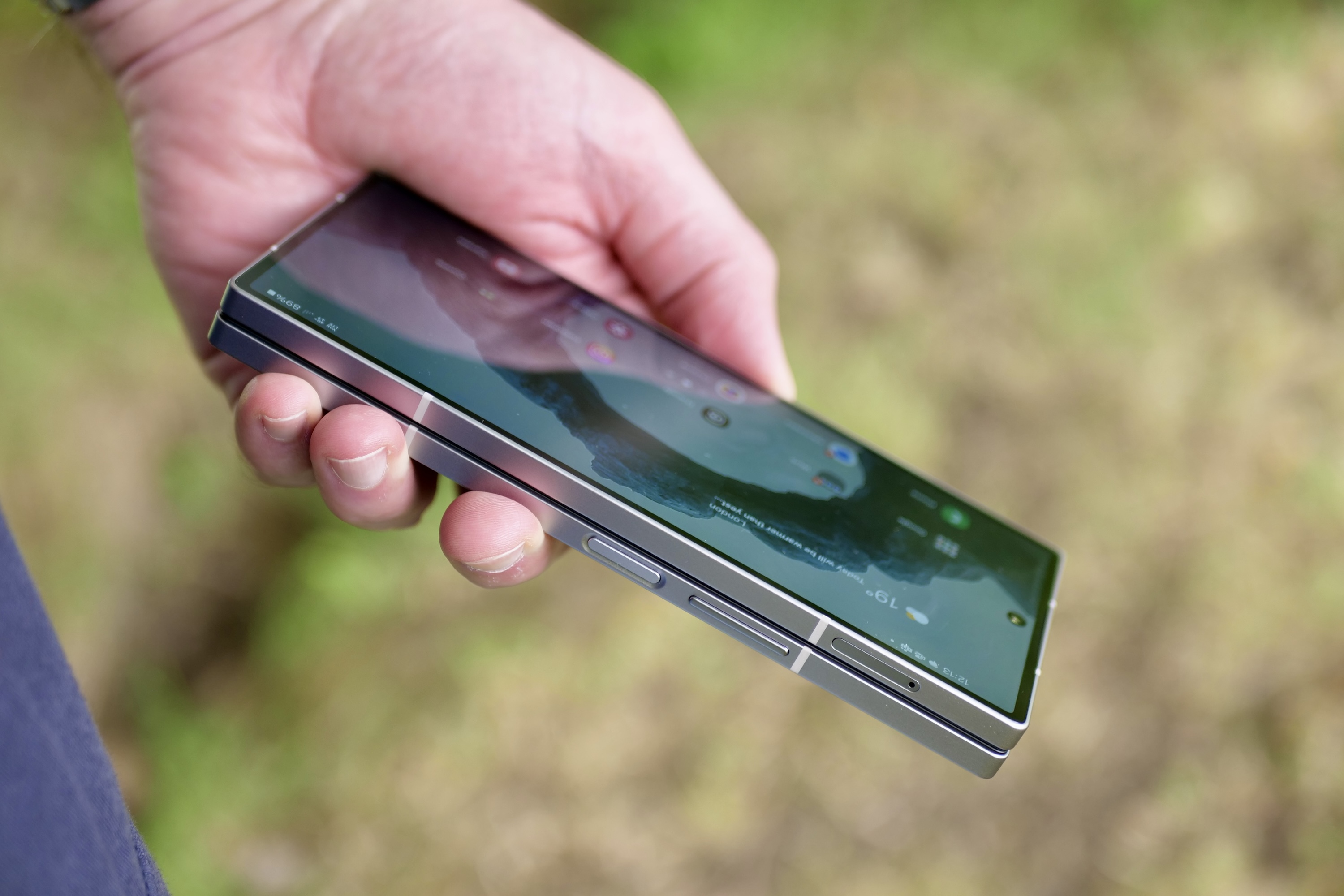 A person holding a closed Samsung Galaxy Z Fold 6, showing the buttons.