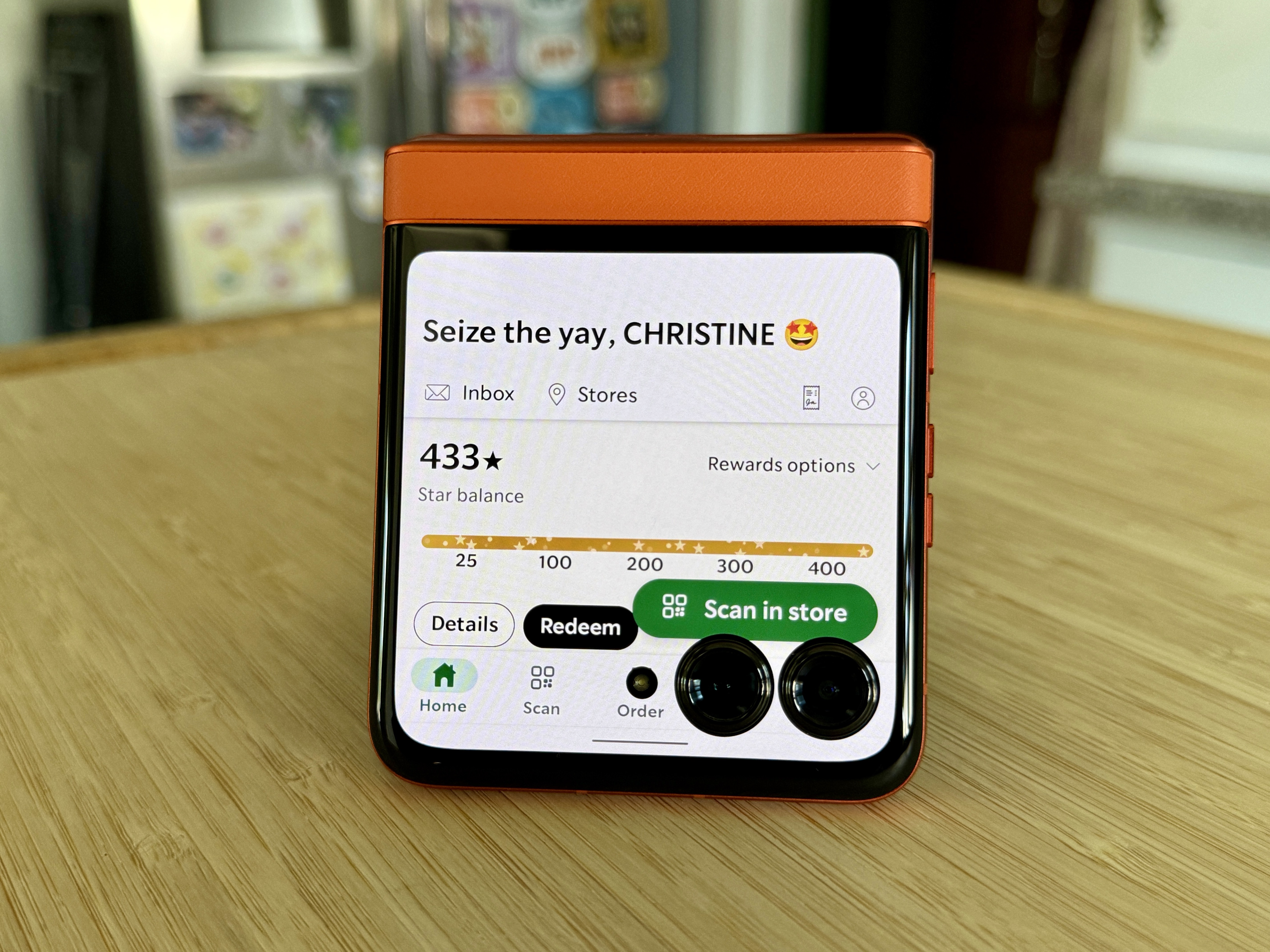 Motorola Razr 2024 in Spritz Orange showing the Starbucks app on the cover display.