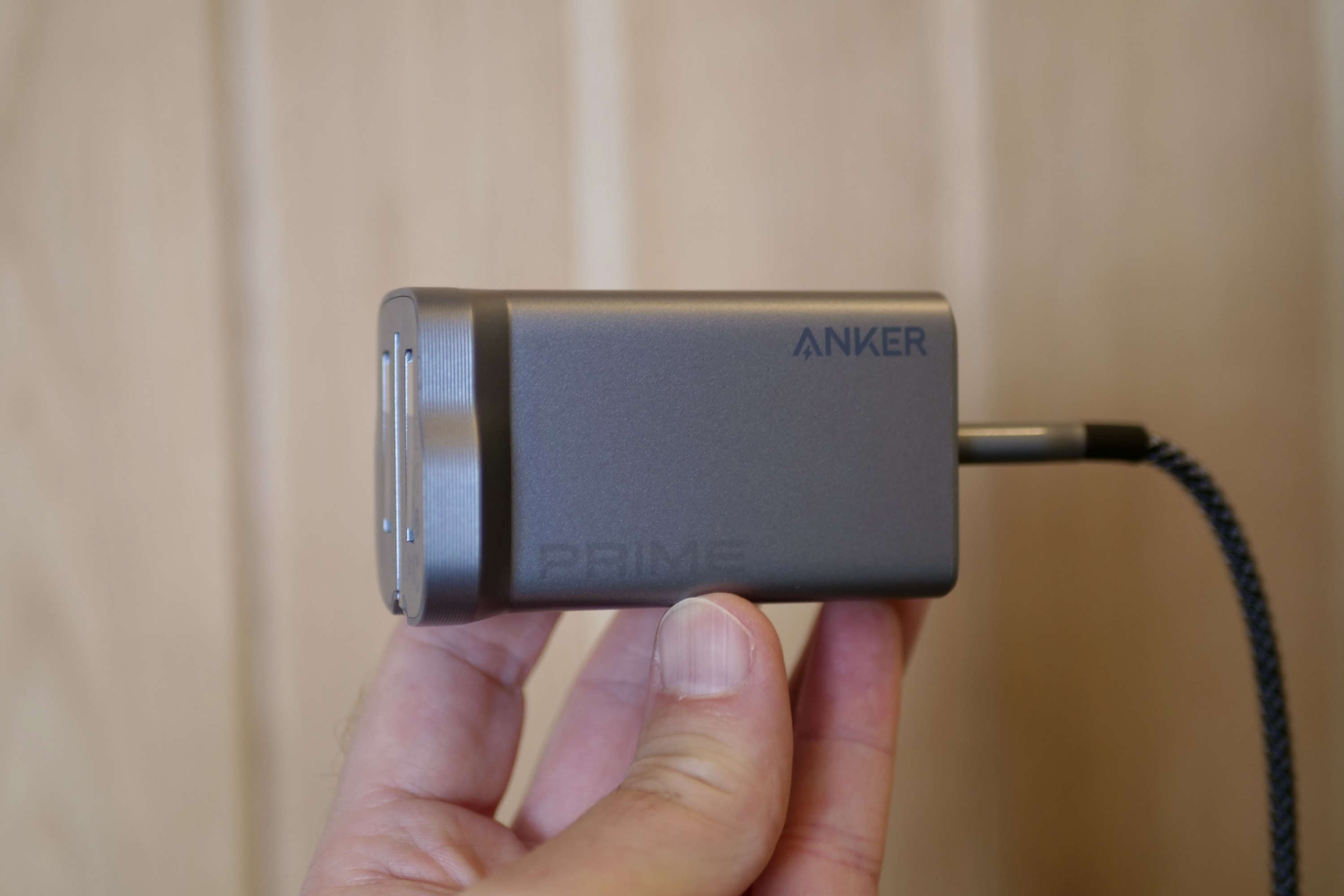 A person holding the closed up Anker Prime Wall Charger.