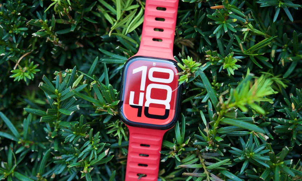 The Apple Watch Series 10 sitting on top of a green bush.