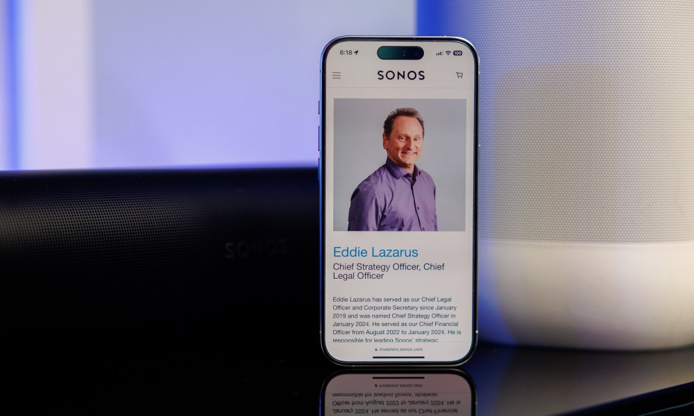 The bio page for Sonos executive Eddie Lazarus as seen on an iPhone in front of Sonos speakers.