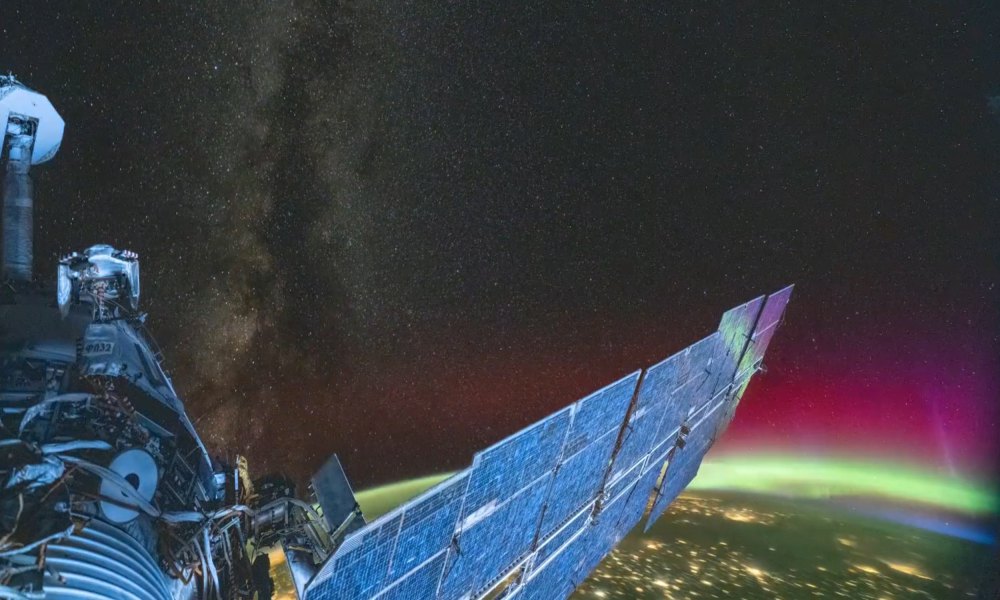 An image taken from the ISS showing featuring Earth, an aurora, the Milky Way, and the station itself.