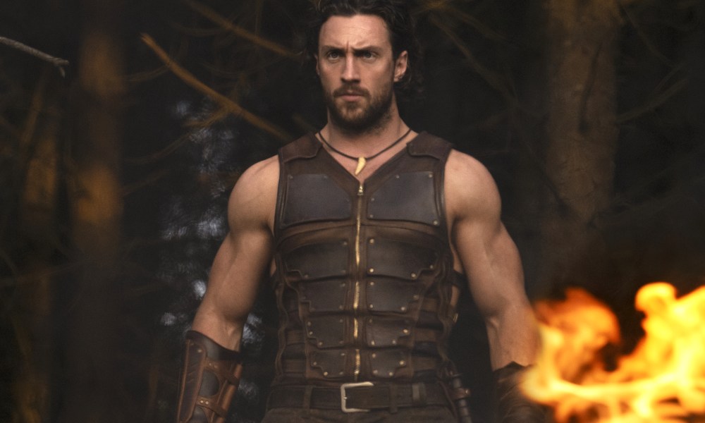 Aaron Taylor-Johnson stands near fire in Kraven the Hunter.