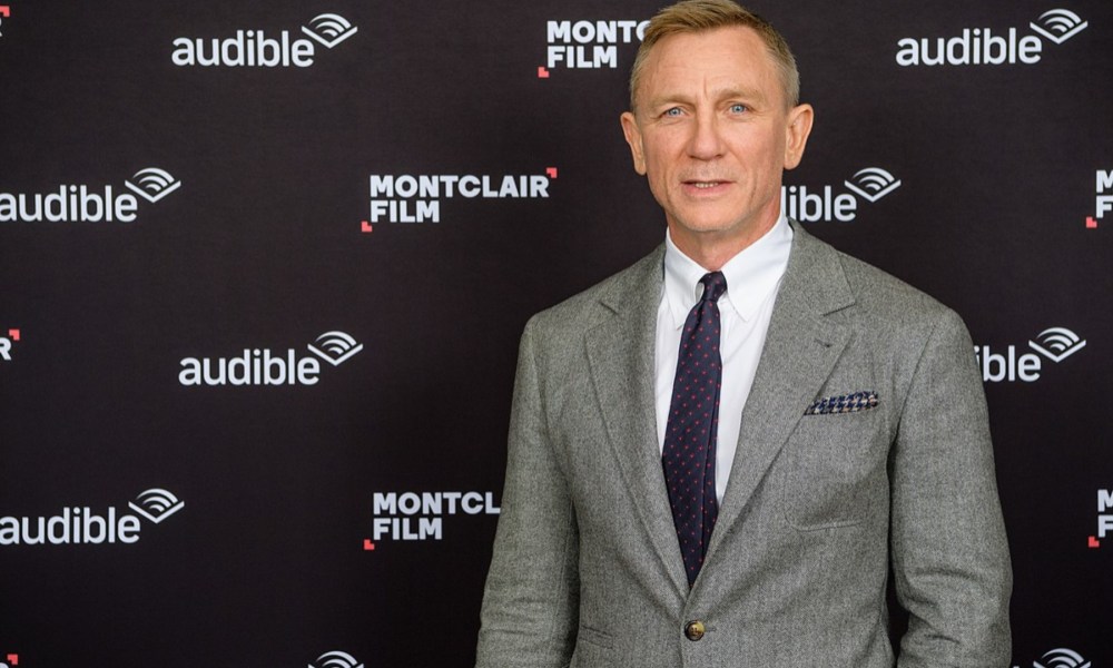 Daniel Craig stands on the red carpet and poses.