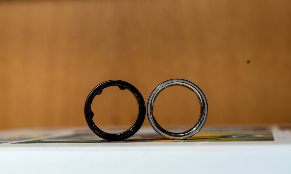 Oura Ring 3 in front of the Oura Ring 4 to show the difference in sensor design.