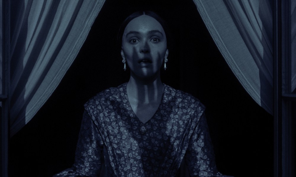 A clawed hand's shadow covers Lily-Rose Depp in a still from the 2024 movie Nosferatu.