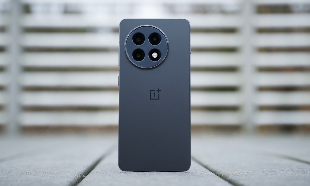 The OnePlus 13R standing upright, showing the back of the phone.